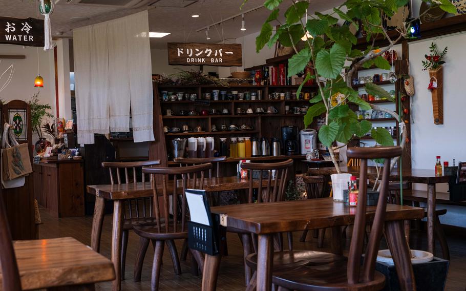 The interior of Do ~ me Gohan Café. Some tables and chairs are visible.